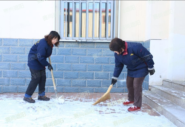 揮舞著鐵鍬和笤帚，相互配合掃雪圖片